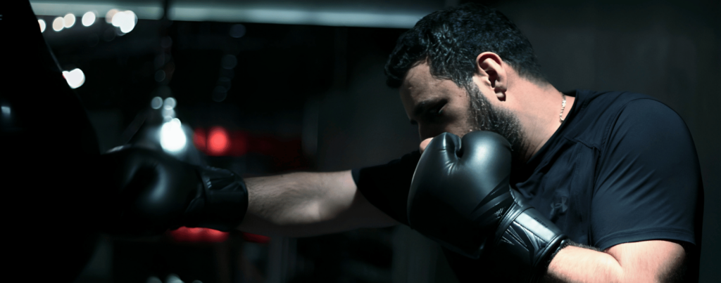 a guy is looking to punch an object while he is guarding himself with one arm