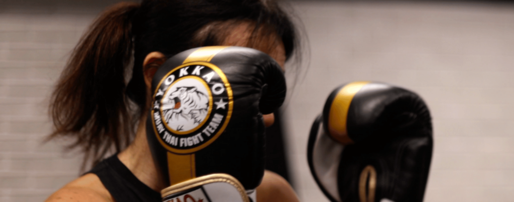 a woman is with boxing gloves guarding herself