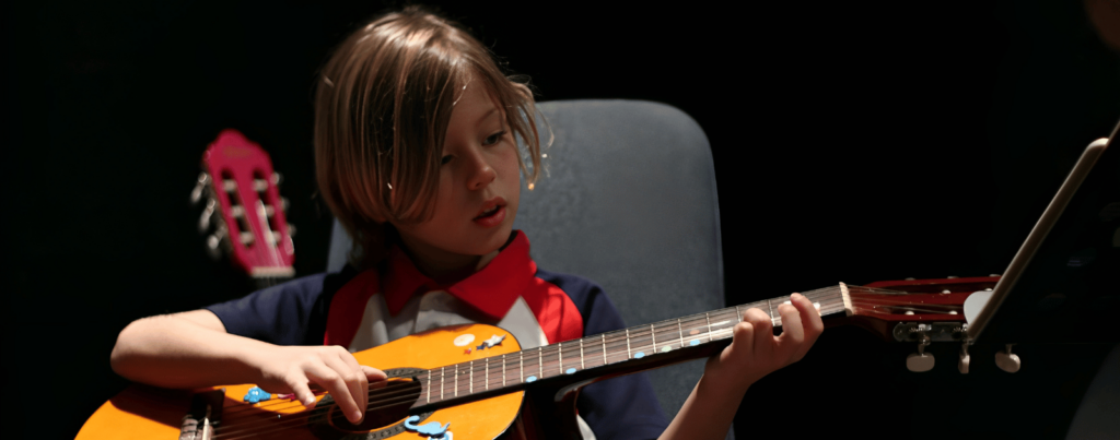 a kid is playing guitar