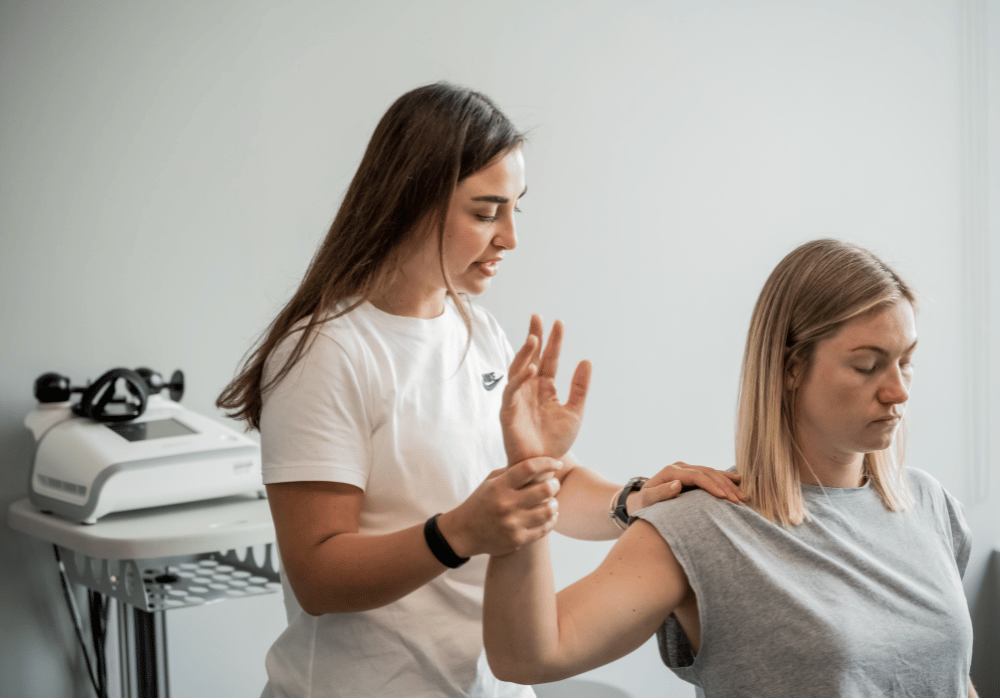 a woman is helping another woman with physiotherapy